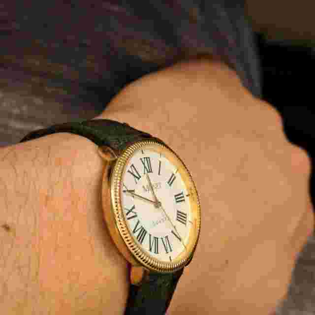 Monet Unisex Gold Tone Roman Numeral Quartz Black Buckle Band Analog Watch