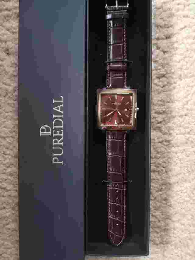 This Puredial watch has a dark brown leather band with a square stainless bezel