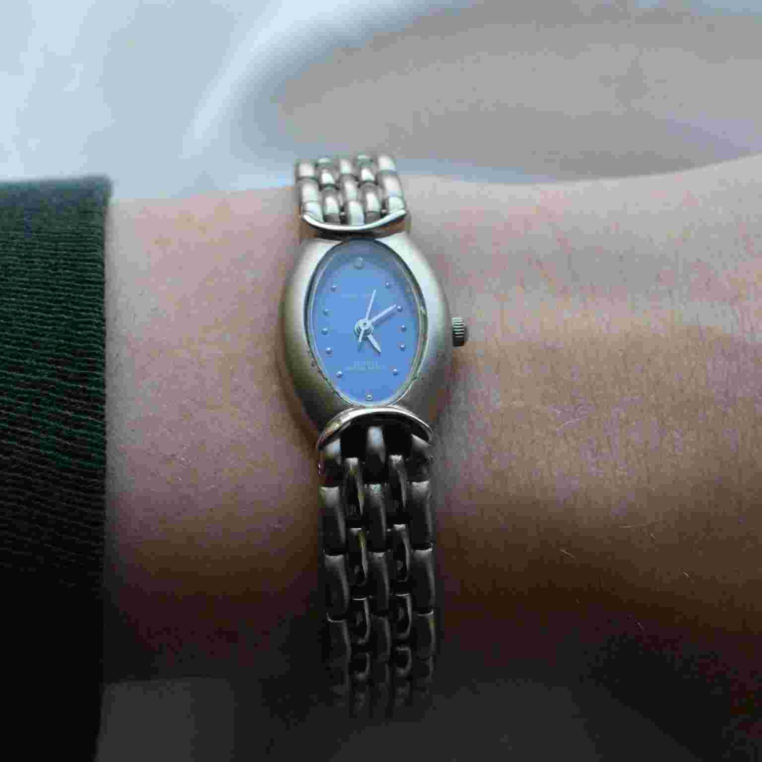 Women’s Quemex silver toned clasp band style watch.