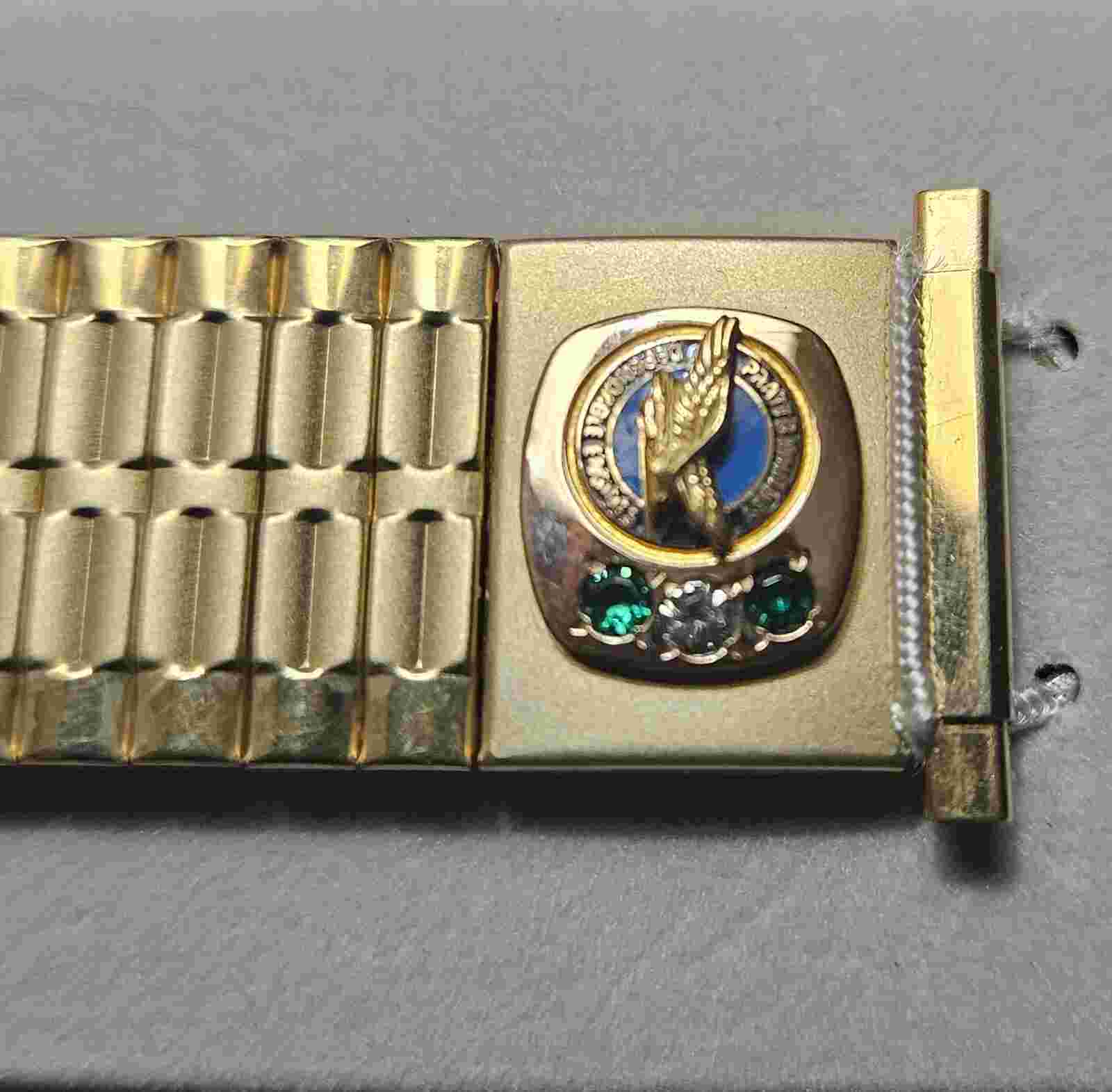 Pratt Whitney  gold metal watch band with two emeralds and a diamond